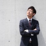空を見上げている若いスーツ姿の男性