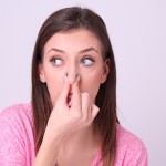 鼻をつまんでいる若い女性