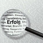 虫眼鏡で小さい文字を拡大している様子