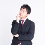 顎に手を当てて考え込んでいる男性