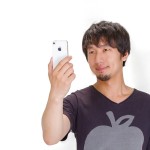 スマホを手に持って見ている若い男性