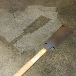 のこぎりでコンクリートを保護し、その周囲に高圧洗浄機による掃除を行い、その後のこぎりをどかした状態