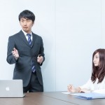 プレゼン中の男性と、その姿を見つめている女性