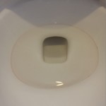 ピンク色の輪っか状の汚れが付着しているトイレの便器
