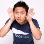 耳に手をあてている若い男性