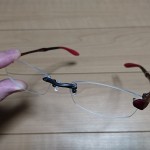 左手で持っている眼鏡市場で購入したふち無しのメガネ