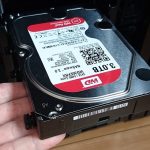 3.5インチ内蔵型HDDを、PC-A76XフルタワーケースのHDDケージにセットする様子