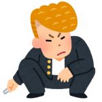 座り込んでタバコを吸っている金髪リーゼントの若い男性