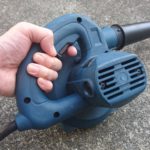 ブロワーのトリガースイッチを左手で引いている様子