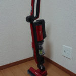 コードレスタイプの赤いスティック型掃除機 日立 PV-BE400の自立している様子