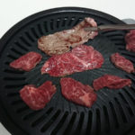 軽い力でつかめる焼肉トング C-3478で肉を挟んで、焼き肉プレートを使って牛ハラミを裏返している様子