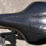 表面がひび割れし、穴が空いている自転車のサドル