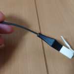 黒いフラットタイプのLANケーブルのコネクター部を横から見た様子